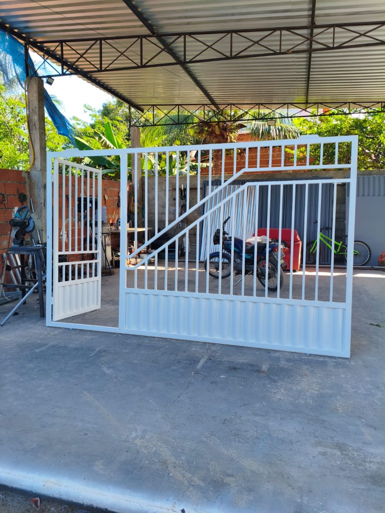 Portão branco com barras verticais, desenho em diagonal e portão de pedestre aberto